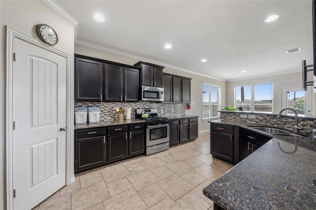 A chef's delight, the kitchen is equipped with granite countertops, stainless steel appliances, ample cabinetry, and a central island, providing both functionality and style.
