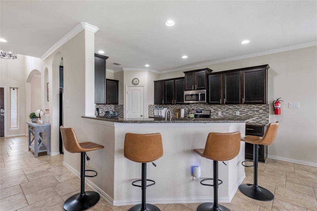 A chef's delight, the kitchen is equipped with granite countertops, stainless steel appliances, ample cabinetry, and a central island, providing both functionality and style.
