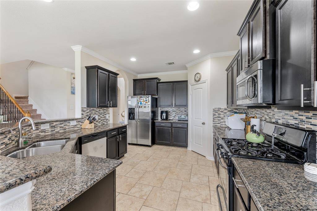 A chef's delight, the kitchen is equipped with granite countertops, stainless steel appliances, ample cabinetry, and a central island, providing both functionality and style.