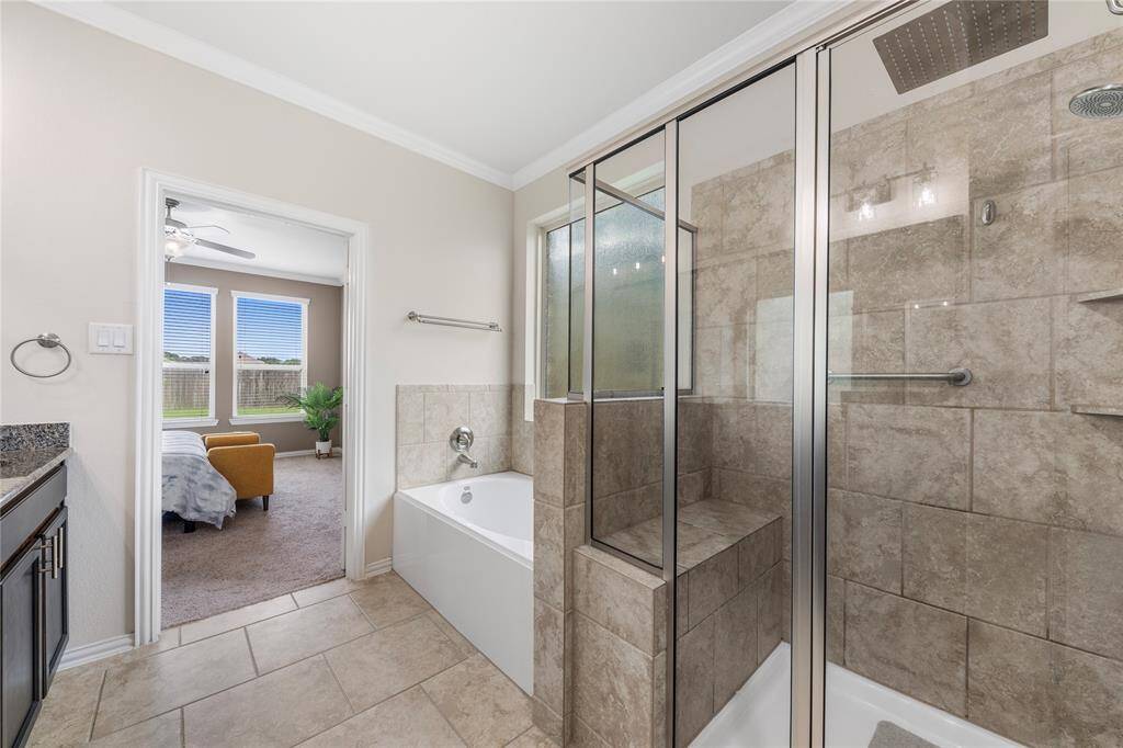 Located on the first floor, the oversized primary bedroom serves as a private retreat, featuring a luxurious en-suite bathroom with a soaking tub, dual vanities, and a separate shower.
