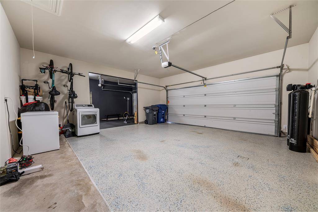 The three-car garage includes finished walls, durable flooring, and overhead storage options, offering both functionality and extra room for equipment, bikes, or a home workshop.
