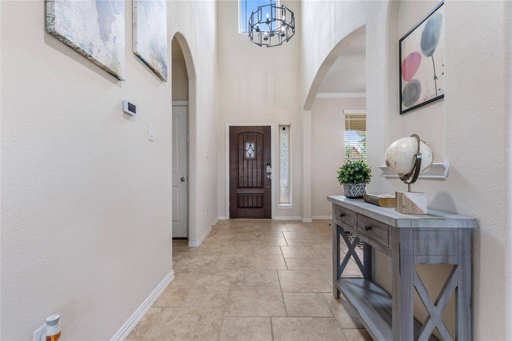 Upon entering, you're greeted by a grand foyer with soaring ceilings and abundant natural light, setting a welcoming tone for the rest of the home