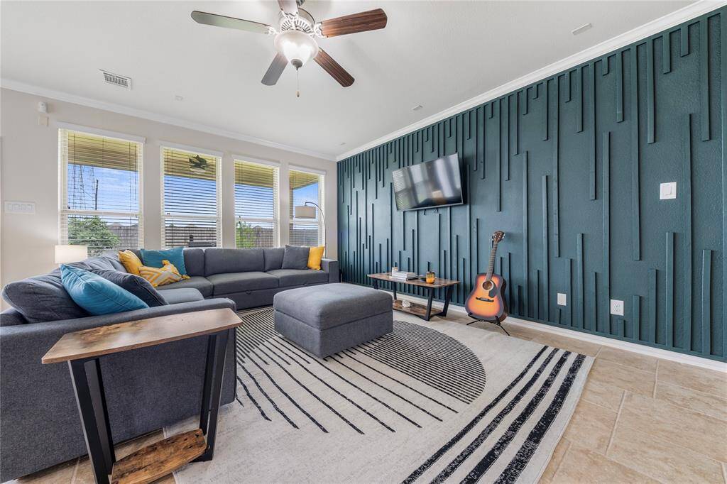 The expansive family room features large windows that flood the space with light, seamlessly connecting to the open-concept kitchen and breakfast nook, ideal for both entertaining and daily living.