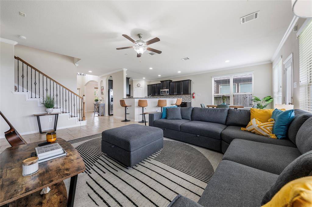 The expansive family room features large windows that flood the space with light, seamlessly connecting to the open-concept kitchen and breakfast nook, ideal for both entertaining and daily living.