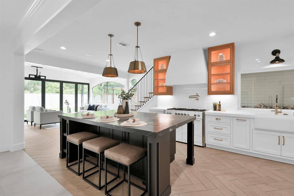 Fully remodeled chef’s kitchen features updated appliances and lighted glass cabinetry.