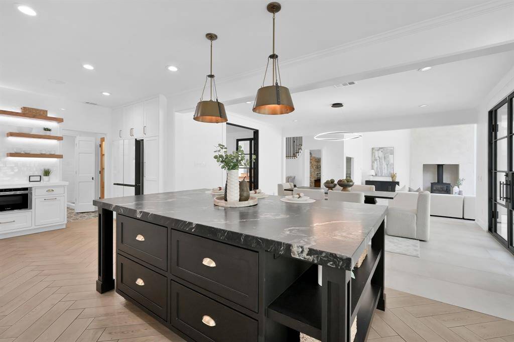 Open concept kitchen gives visibility to dining room and living room.  Refrigerator in the far corner blends with the pantry cabinetry on each side.
