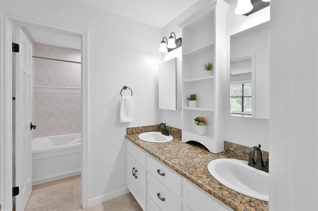 En-Suite bathroom to upstairs bedroom #1 includes a contemporary styled tub/shower combo.