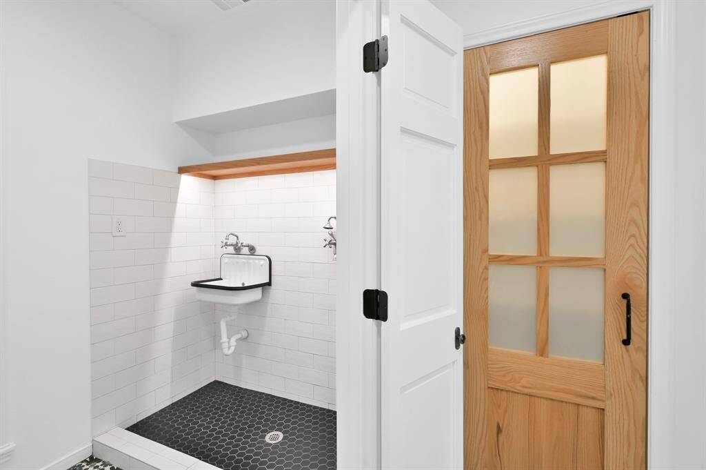Half Bathroom (north) and Utility Room are located behind the kitchen wall. Exterior door leads outside to covered carport.