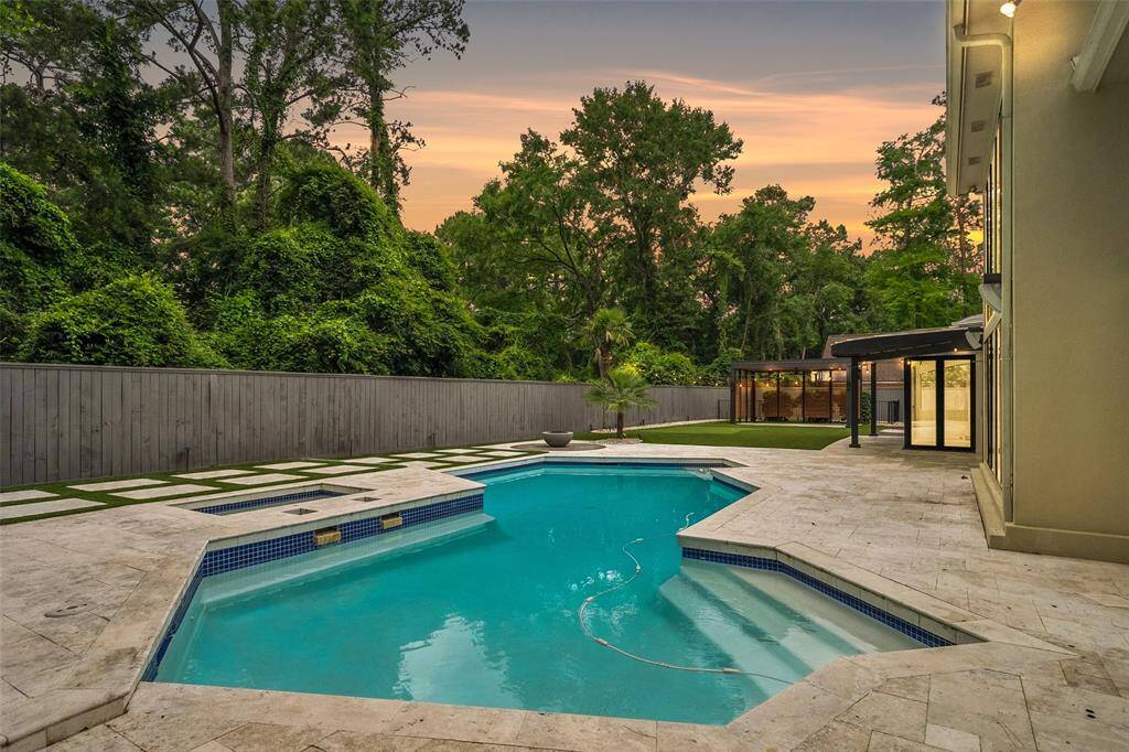 This spacious backyard offers a heated pool and spa, with luxury travertine patio decking, perfect for outdoor  entertaining.