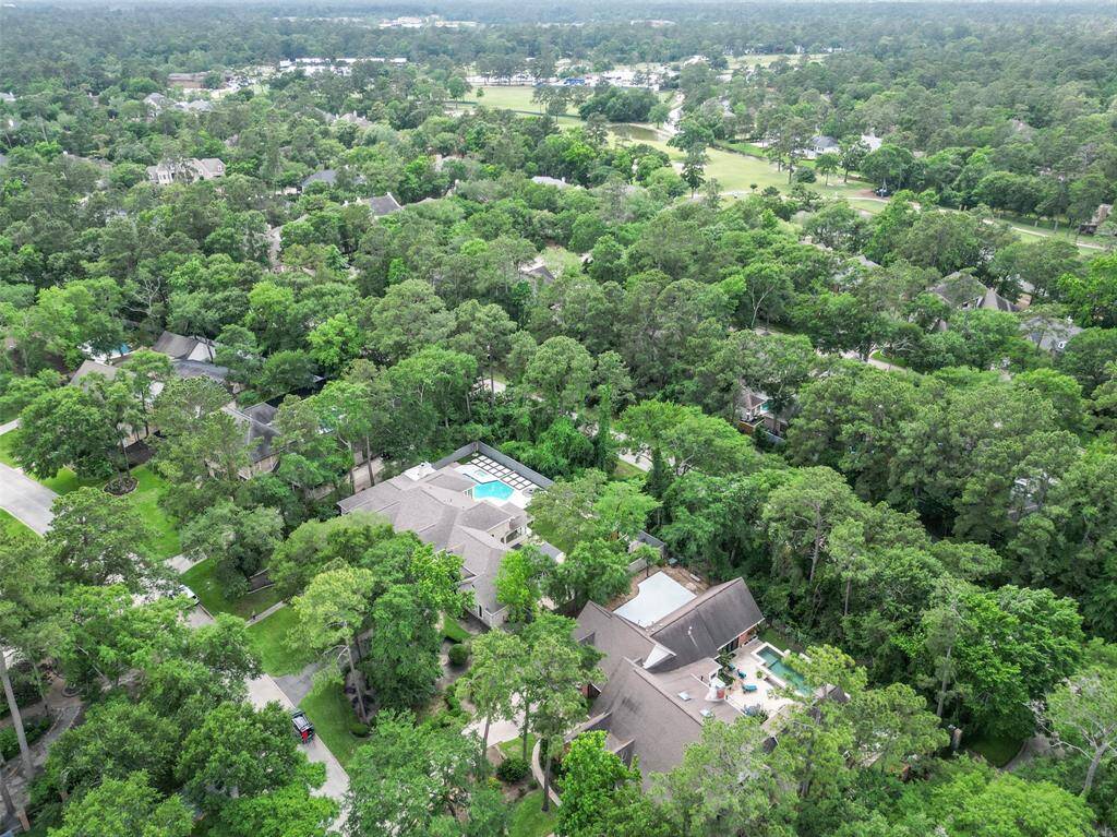 This aerial view showcases the full array of luxury outdoor features surrounded by lush greenery.