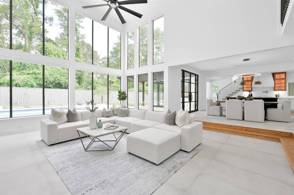 Spectacular wall of windows brightens the open concept main living area by day.