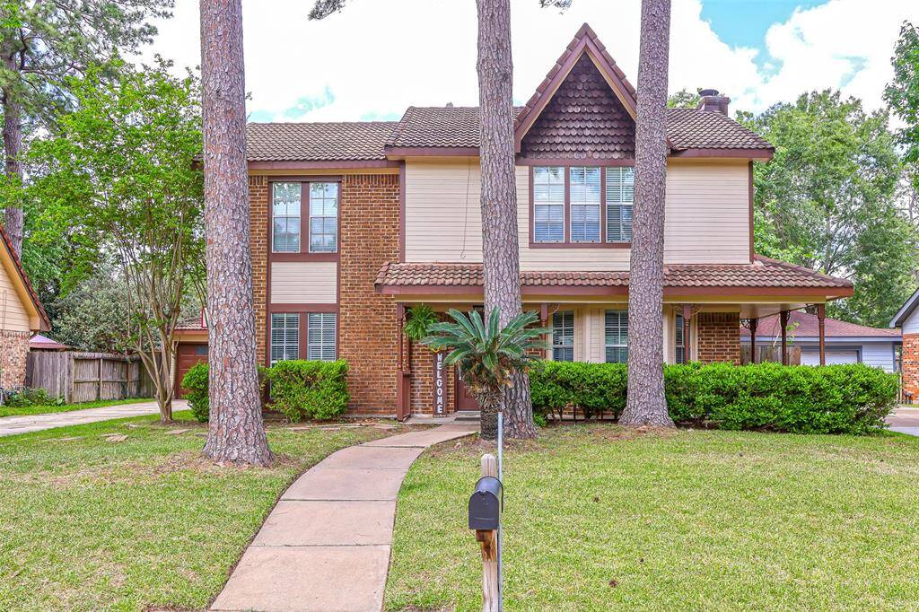 Charming two-story home with a brick and siding exterior. It features a welcoming front walkway, mature trees, and well-maintained landscaping. The house has a classic design with large windows for natural light.