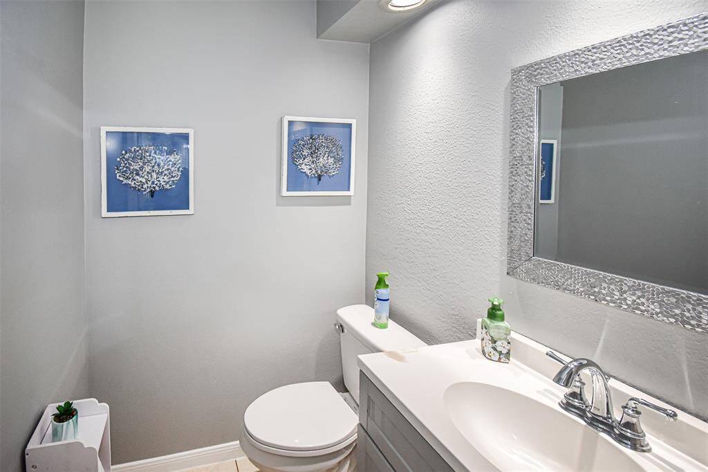 This stylish half bath featuring modern fixtures, a sleek vanity with a decorative mirror, and subtle decor that adds a touch of elegance.