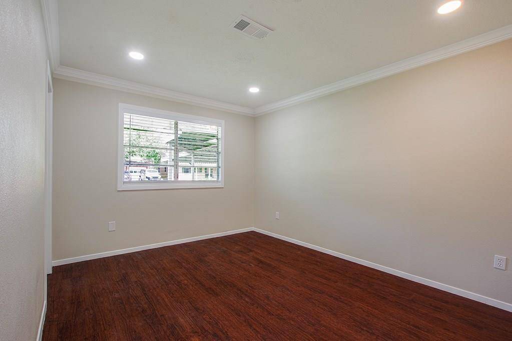 Bedroom with hardwood floors andwindow.