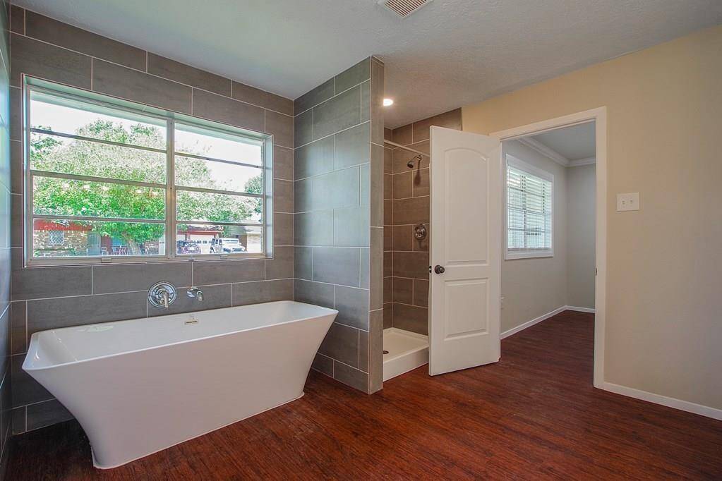 Bathroom has both standing showerand Japanese soaking tub, under alarge window with fresh tile.