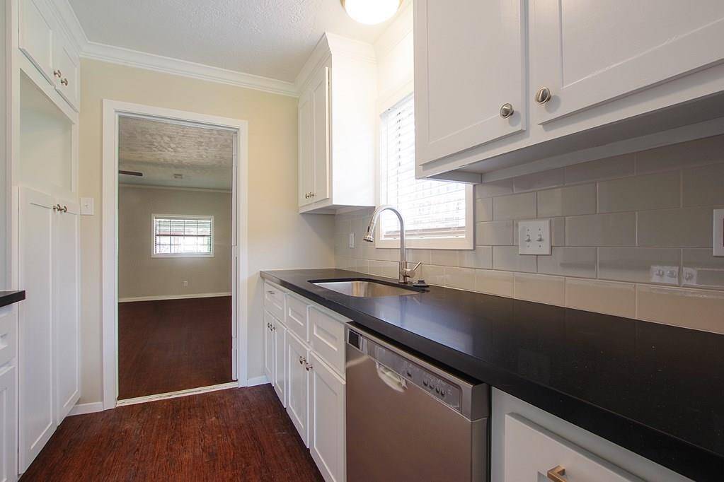 Newly remodeled kitchen with stonecountertop opens into the living room.