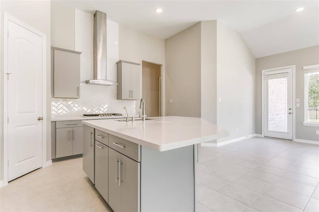 Gray cabinets adds to the light and bright feel of the home and is accompanied with Tile Flooring and a Beautiful View of the Backyard while cooking!