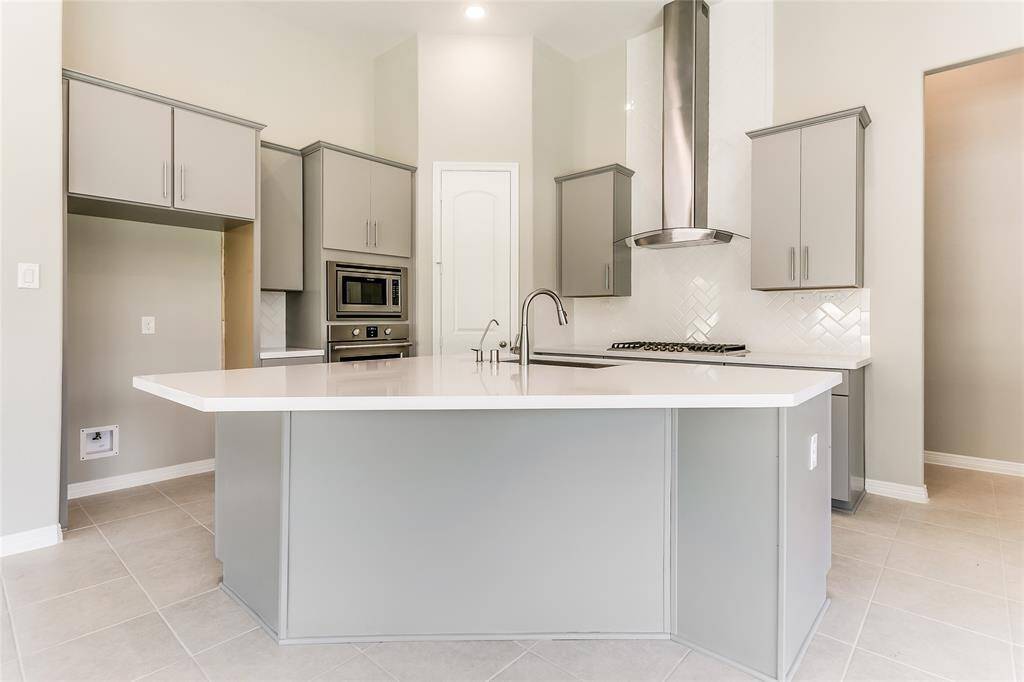 Goegeous Gourmet Kitchen that offers a Grand Island, Stainless Steel Appliances, and soaring ceilings.