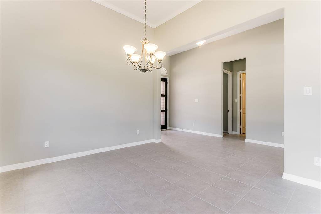 Divine Dining Room accompanied with Tile Flooring, chandelier, and an abundant of space to entertain guests!
