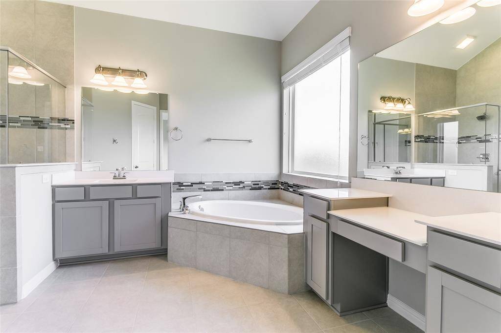 Spacious Primary Oasis that is accompanied with Terrific Tile Flooring, window for natural lighting, and large corner tub to relax in after a long day!