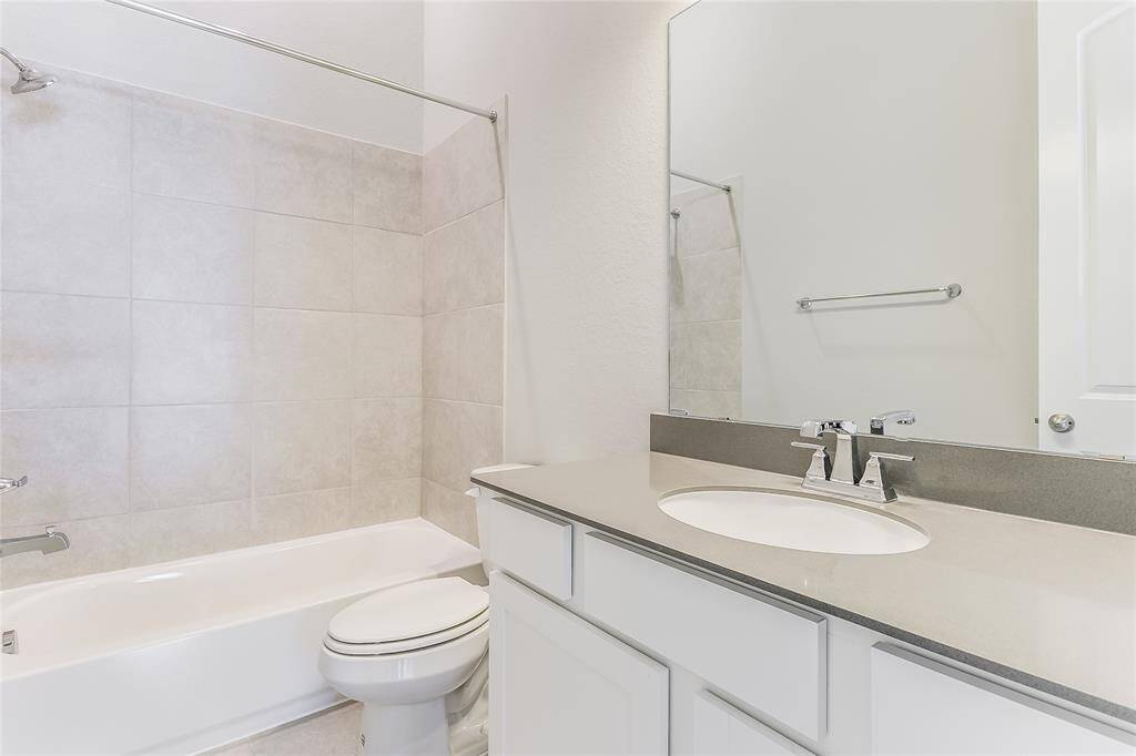 Large Secondary Bathroom that offers tub and shower combination with tile backsplash and light cabinetry to add to the Elegant ambiance.