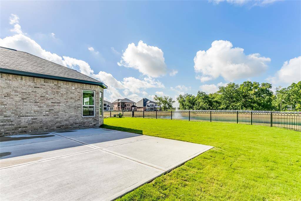 Charming Large Patio out back to enjoy the abundance of green space and the serene view of the beautiful Lake out back while entertaining guests.