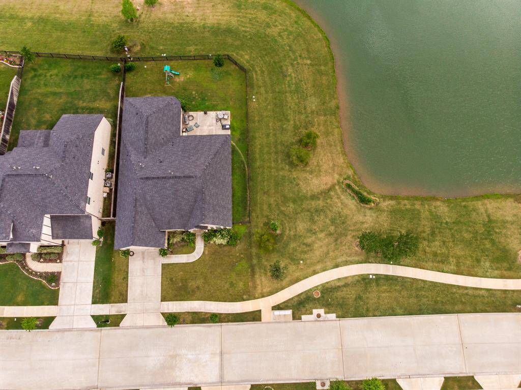Aerial view showcasing no back or side neighbors and the stunning LAKEFRONT feature this rare lot has to offer!
