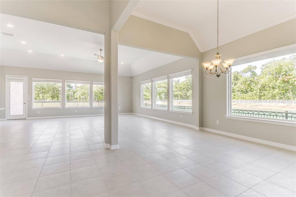 Just look at that Luxurious Living Room that offers an open concept and is accompanied with Wall of Windows for Natural Lighting, Lovely Tile Flooring, Custom Archways, and tons of space to make it your own.