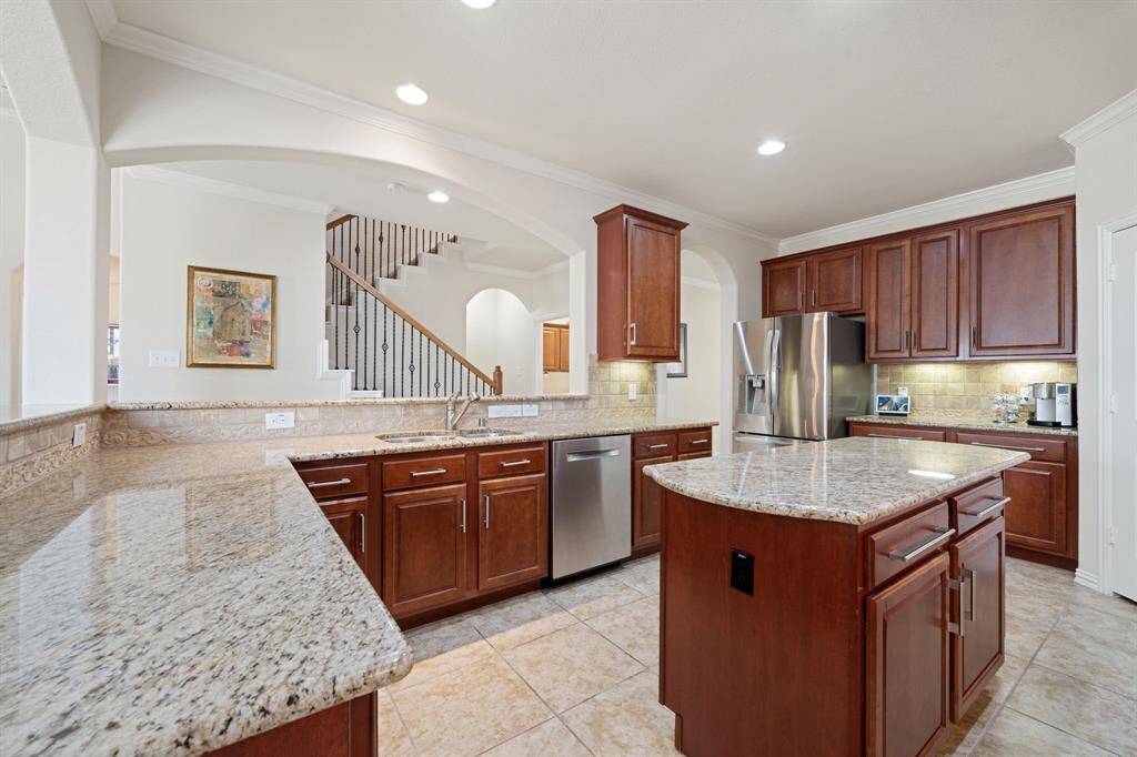Host the next dinner party with confidence! This masterfully-equipped kitchen features a kitchen island, an abundance of cabinet and counter space, crown molding details, recessed lighting, and under cabinet lighting, as well as stainless steel appliances.