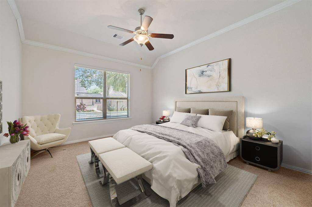 Virtually Staged: Spacious primary bedroom with carpet floors, crown molding details, ceiling fan, windows with privacy blinds, with views straight into your backyard.