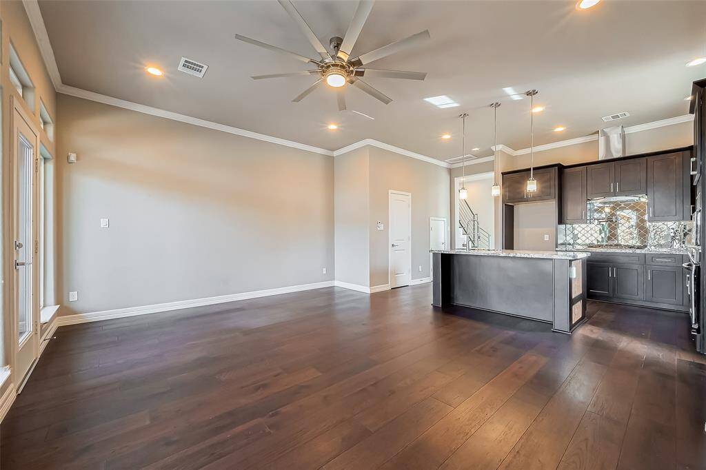 This living room has a large lighted 9-blade ceiling fan that can give both the kitchen and living room plenty of air. Also the breakfast bar has plenty of room for stools.