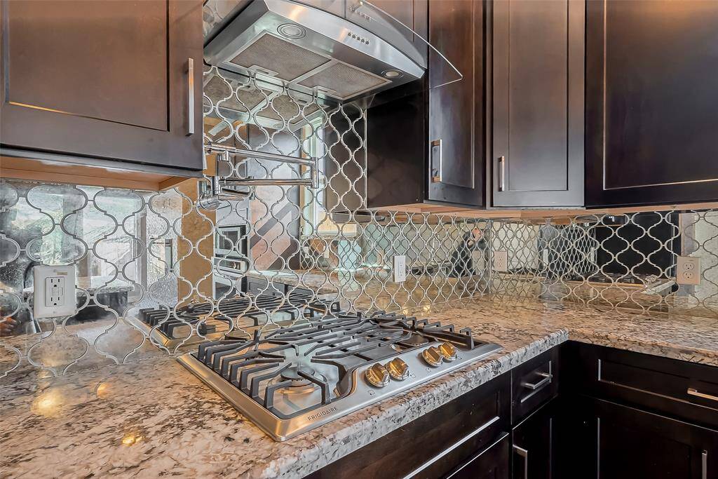 This gas stove has a pot filler to make dinners more convenient. Throughout this home there are beautiful granite countertops.