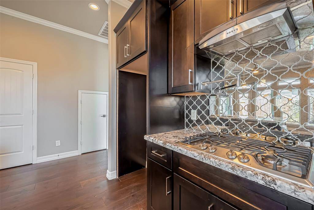 Beautiful mirrored backsplash in genie shape that accents this gourmet kitchen.