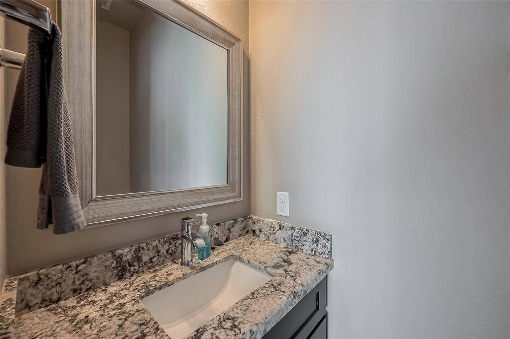 This is the half bath downstairs with a silver contemporary mirror. Perfect for your guests while visiting.