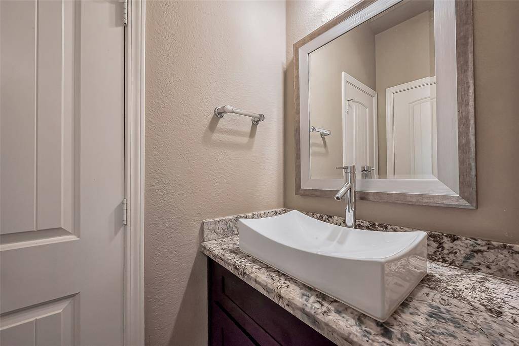 Each jack and jill dressing area has a granite surface with a vessel sink and a modern gray mirror. Each dressing area has a door to close for privacy.