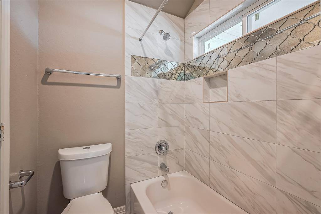 This is a private tube area for the jack and jill bedrooms. The tub area walls are marble and have a band of a genie shape mirrors. There is also plenty of natural lighting above the tub.