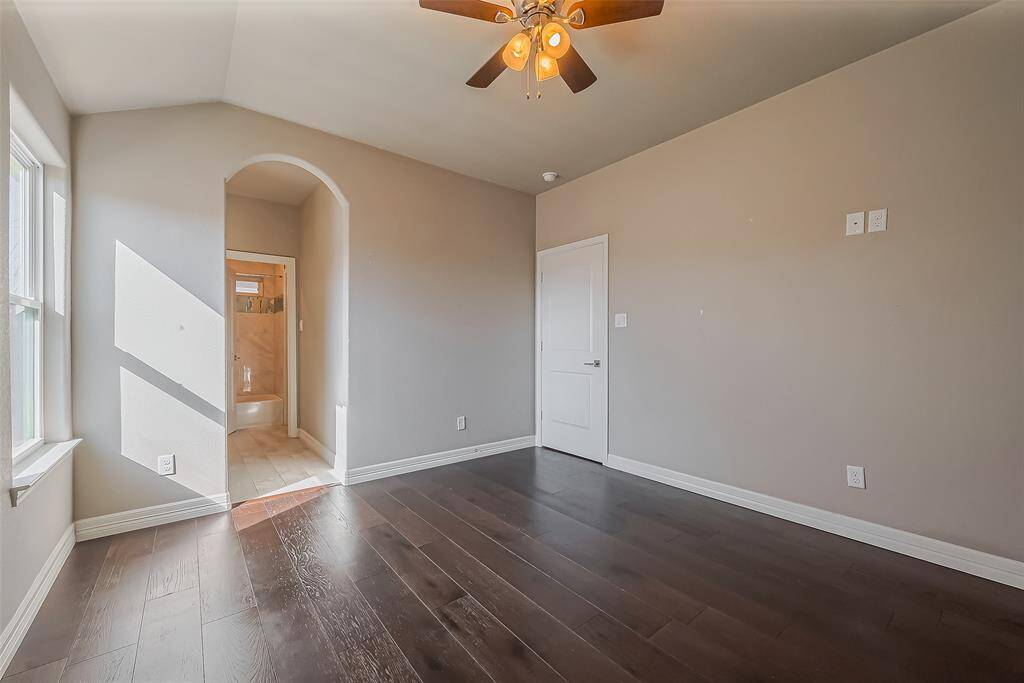 This room has a nice archway from the bedroom into the bathroom area and good natural lighting coming through the window.