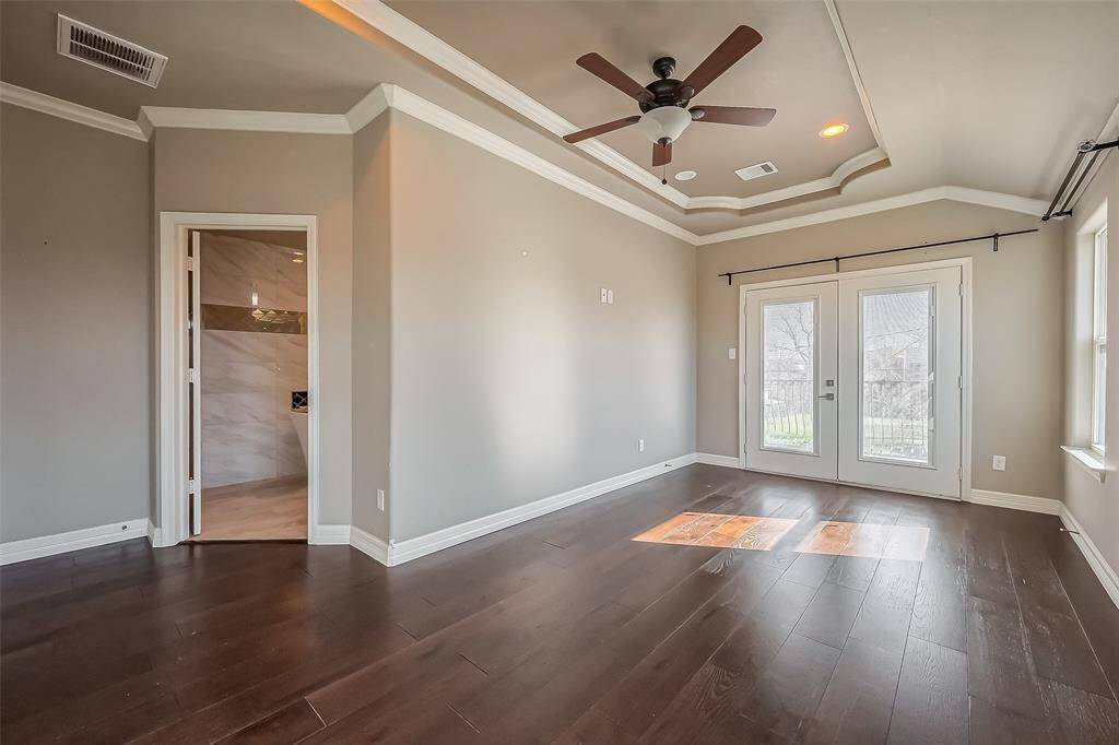 This large primary bedroom has beautiful taupe walls that can accommodate a king size bed.