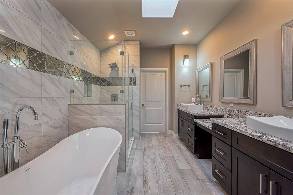 It also has marble walls with a genie glass mirror accent. There is also granite counter tops. The floor also has the gray and white lamanite flooring.