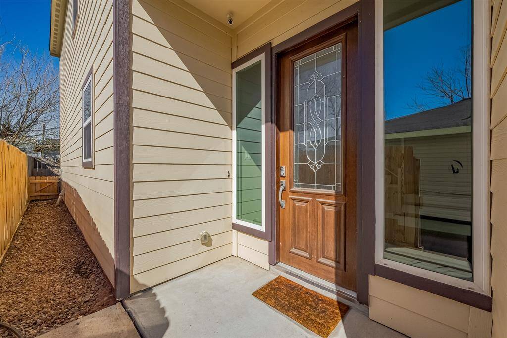 This home has a mahogany wood front door with decorative glass and two sidelights on each side of the door.