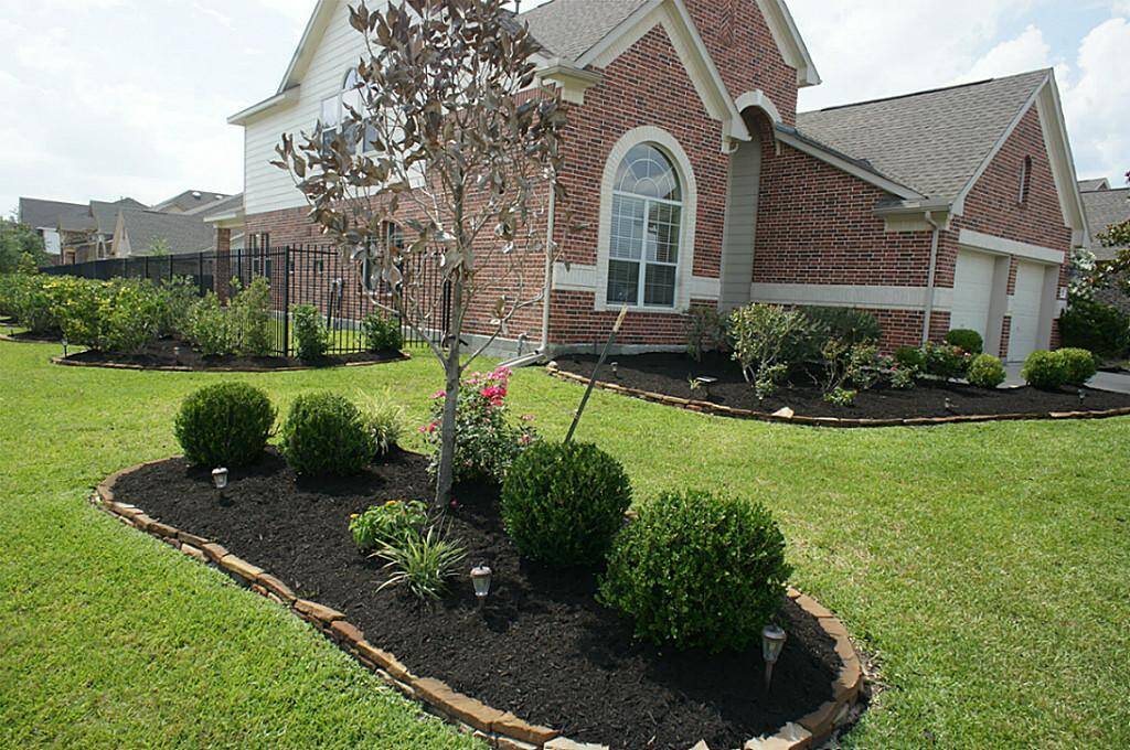 Beautiful bloomed flowers brighten up the yard at this lovely home.