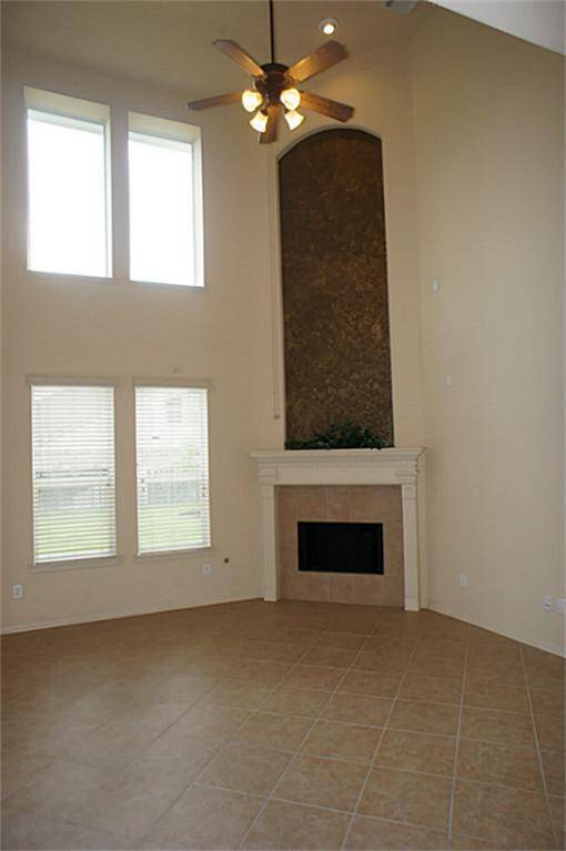 Gaslog fireplace, wall of windows, and tile flooring make up this beautiful living room. Natural light shows off the painted art niches through out the home.