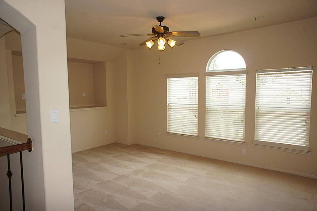 Spacious Gameroom offers natural light! Plenty of space for a sectional! Check out the tv niche.