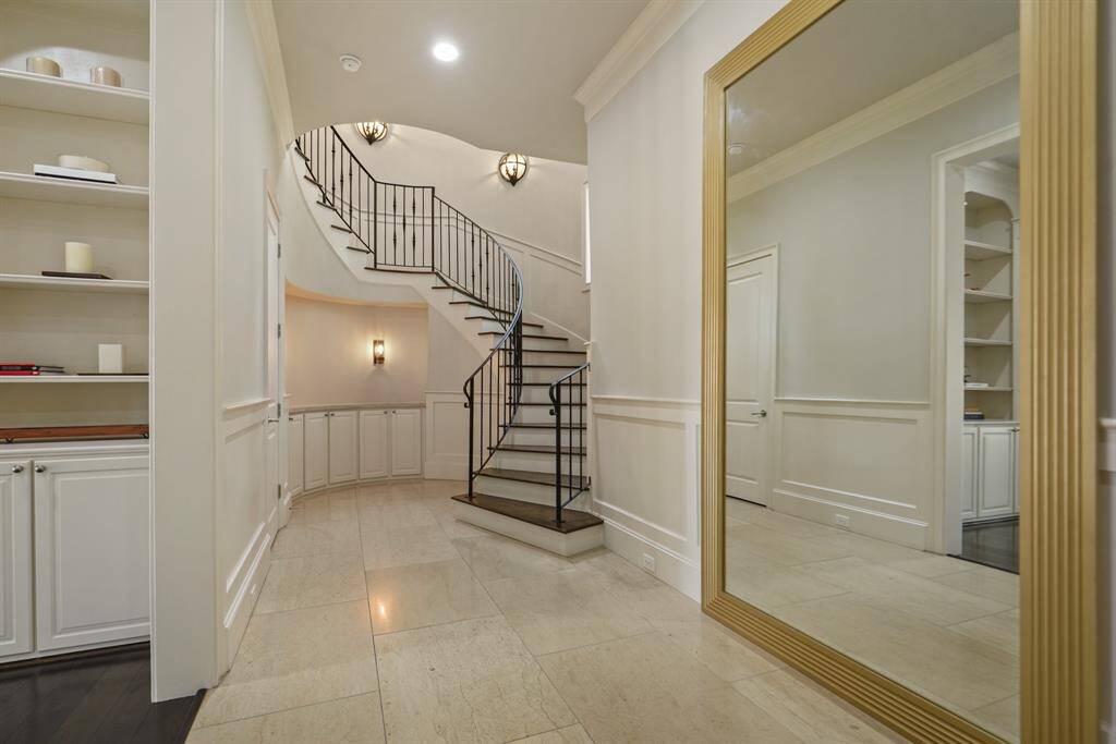 A stunning staircase with a custom mirror and elegant lighting creates a captivating entrance.
