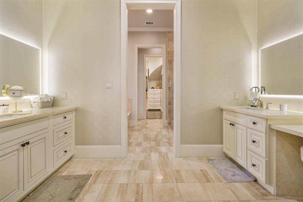 Elegant master vanities with custom-lit mirrors for a luxurious touch.