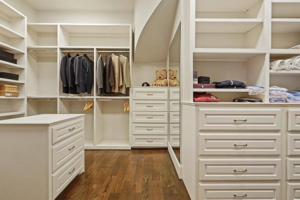 Spacious walk-in closet with elegant built-in storage.