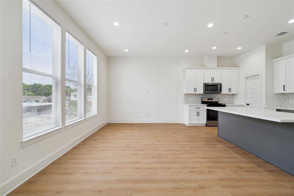 The spacious living area is highlighted by oversized windows, flooding the space with natural light. It’s the perfect place to unwind or entertain in style