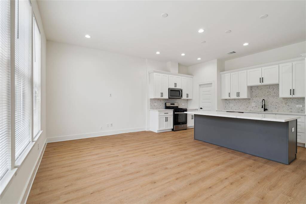 The open concept design creates a seamless flow between the kitchen, dining, and living areas, making it ideal for both everyday living and entertaining. The space feels connected, spacious, and functional.
