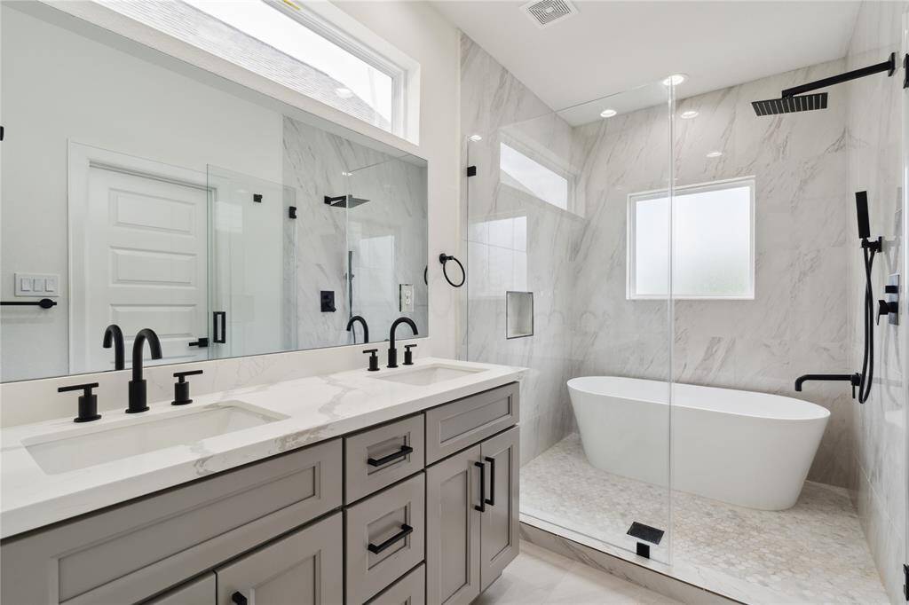 The luxurious primary ensuite features dual sinks for added convenience, alongside a beautifully framed walk-in shower and a separate tub for ultimate relaxation. It’s the perfect blend of style and functionality