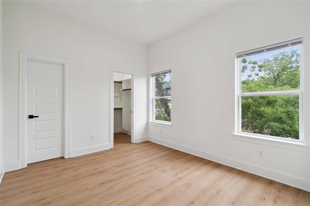 This spacious secondary bedroom offers plenty of room for comfort and versatility, complete with a walk-in closet for added storage. It’s perfect for guests, family, or as a home office